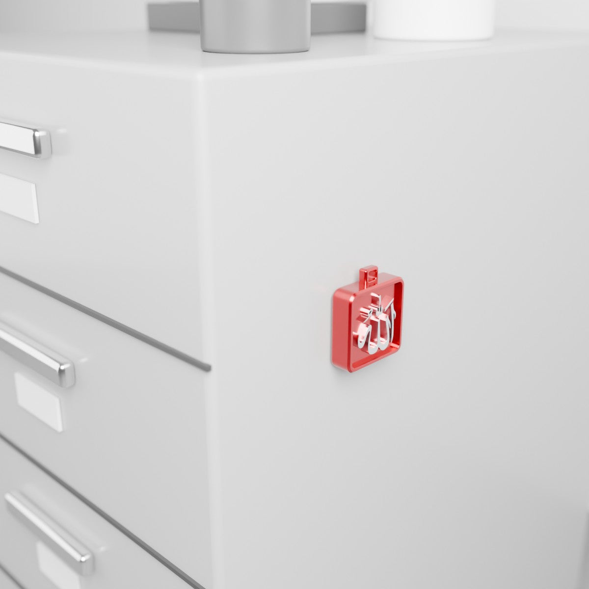 The Allah collectible held by its built-in magnet on the side of a metal office cabinet